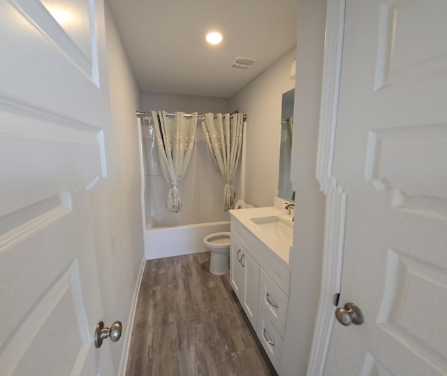 full bathroom with hardwood / wood-style floors, vanity, toilet, and shower / bath combo with shower curtain