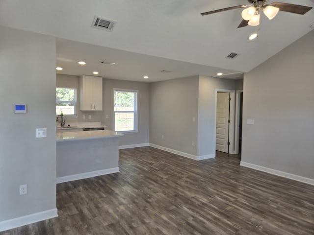 interior space with dark hardwood / wood-style flooring, ceiling fan, sink, white cabinets, and lofted ceiling