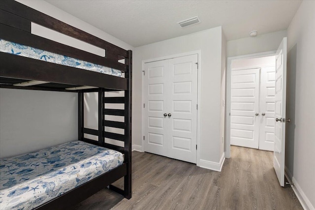 bedroom featuring wood-type flooring and a closet