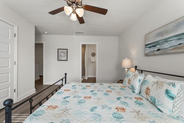 bedroom with a textured ceiling, dark wood-type flooring, and ceiling fan