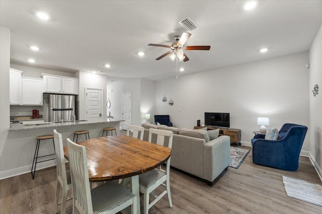 dining room with ceiling fan and light hardwood / wood-style flooring