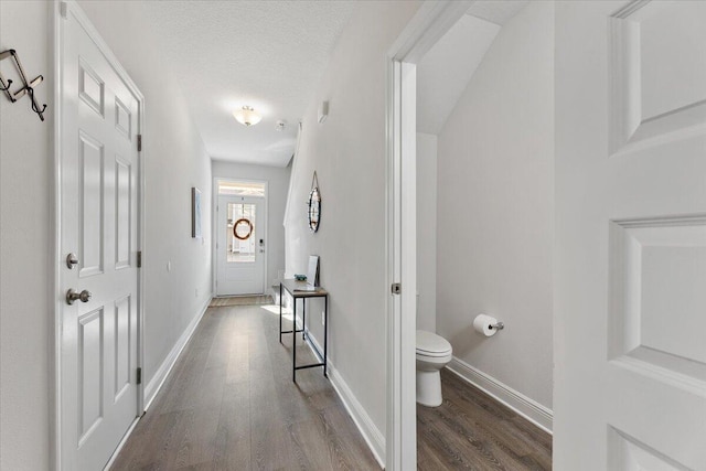 corridor with wood-type flooring and a textured ceiling