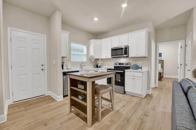 kitchen featuring white cabinetry, appliances with stainless steel finishes, and light wood-type flooring