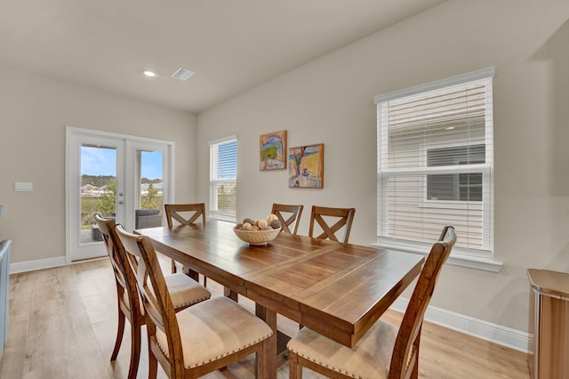 dining space with plenty of natural light, light hardwood / wood-style flooring, and french doors