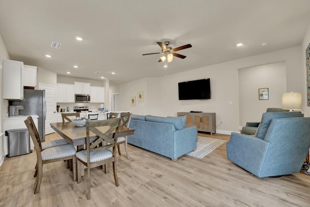 dining space featuring light wood-type flooring and ceiling fan