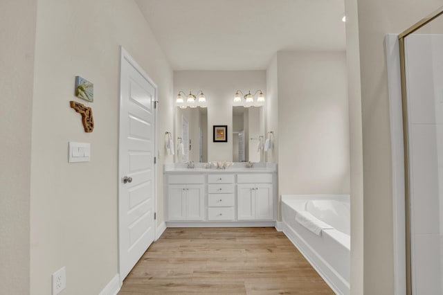 bathroom with vanity, hardwood / wood-style floors, and a bathing tub