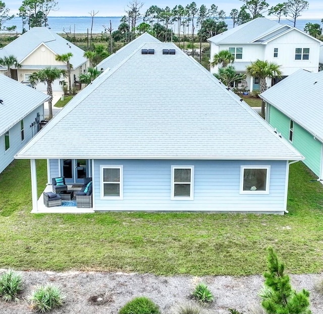 back of property with outdoor lounge area, a lawn, and a patio