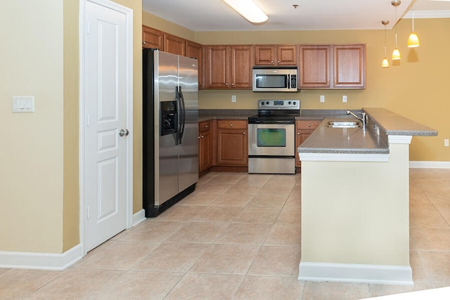 kitchen with kitchen peninsula, sink, decorative light fixtures, light tile patterned floors, and appliances with stainless steel finishes