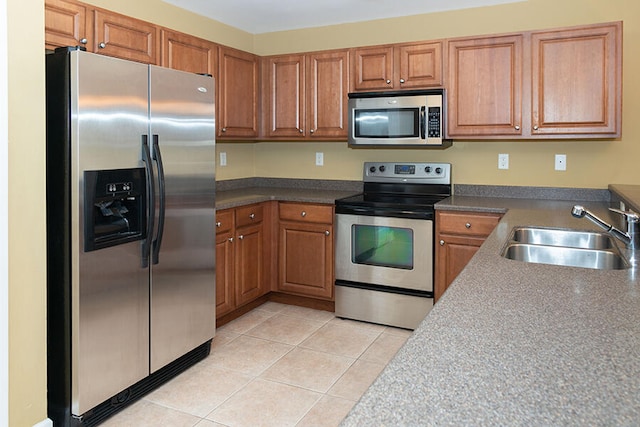 kitchen featuring appliances with stainless steel finishes, sink, and light tile patterned floors