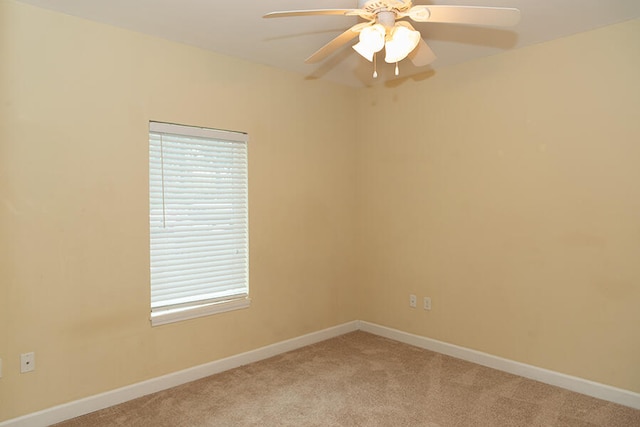 carpeted spare room with ceiling fan