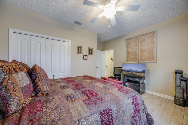 bedroom with a closet, ceiling fan, a textured ceiling, and light hardwood / wood-style flooring