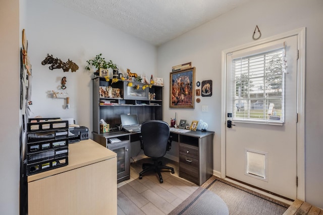 office with a textured ceiling and light hardwood / wood-style floors