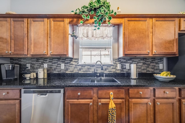 kitchen featuring stainless steel dishwasher, sink, dark stone countertops, and tasteful backsplash