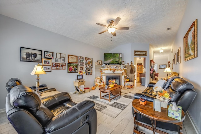 living room featuring light hardwood / wood-style flooring, a textured ceiling, lofted ceiling, and ceiling fan