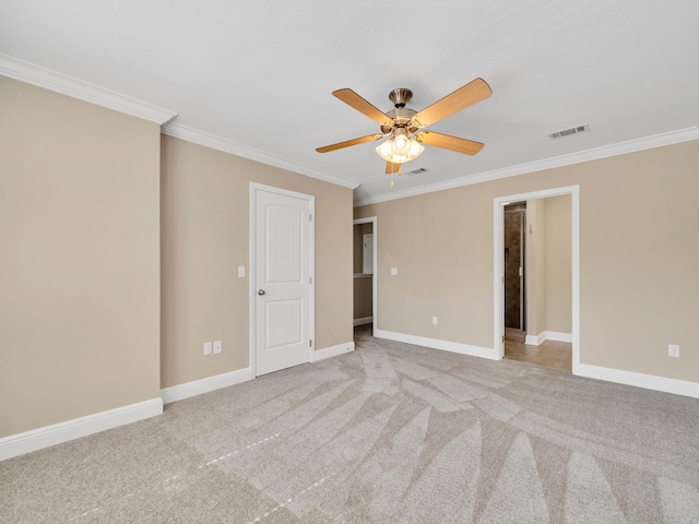 empty room with ornamental molding, light colored carpet, and ceiling fan