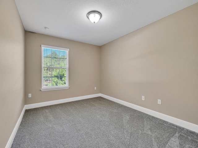 carpeted spare room featuring a textured ceiling