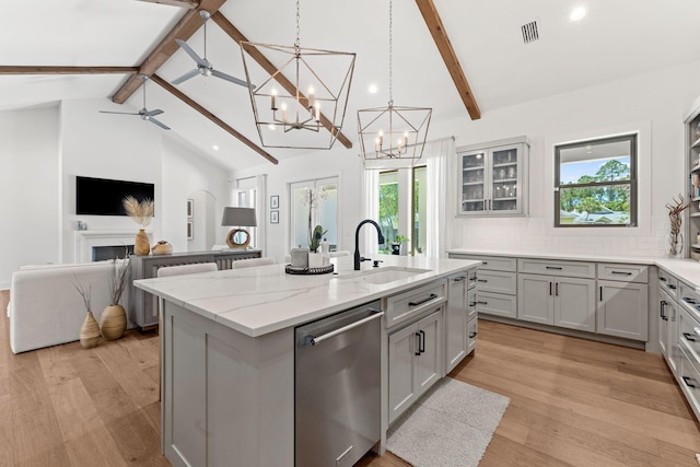 kitchen with light hardwood / wood-style flooring, sink, a wealth of natural light, and a kitchen island with sink