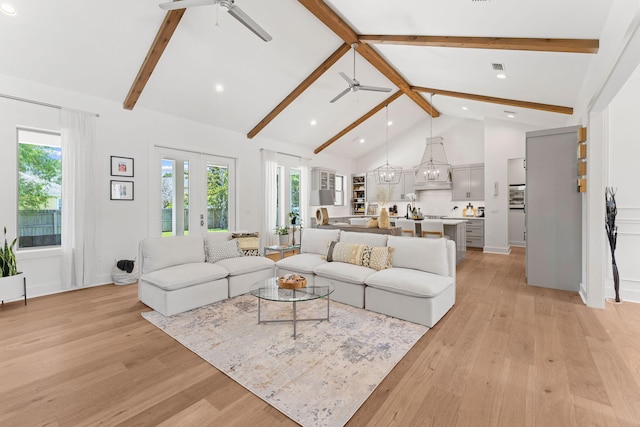 living room with light hardwood / wood-style floors, beamed ceiling, high vaulted ceiling, and ceiling fan with notable chandelier