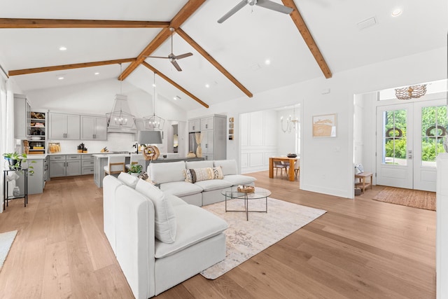 living room with beam ceiling, high vaulted ceiling, ceiling fan with notable chandelier, and light hardwood / wood-style floors