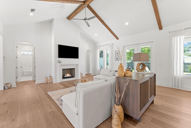 living room with beamed ceiling, high vaulted ceiling, light hardwood / wood-style floors, and ceiling fan