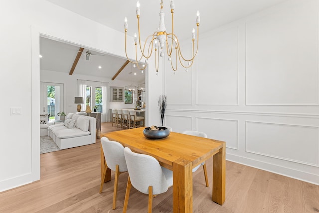 dining space featuring light hardwood / wood-style floors, vaulted ceiling with beams, and ceiling fan with notable chandelier