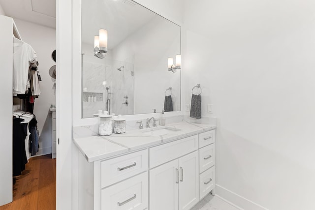 bathroom with vanity, hardwood / wood-style flooring, and walk in shower