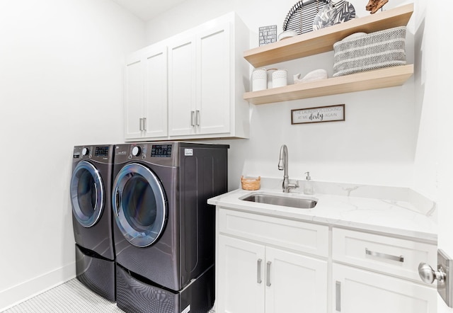 laundry area featuring sink, washing machine and dryer, light tile patterned floors, and cabinets