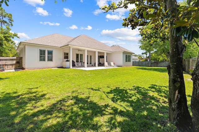 back of house with a yard and a patio