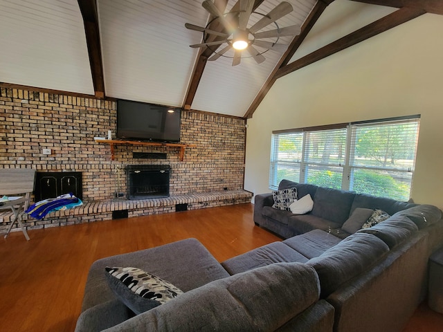 living room featuring a brick fireplace, beamed ceiling, brick wall, and hardwood / wood-style flooring