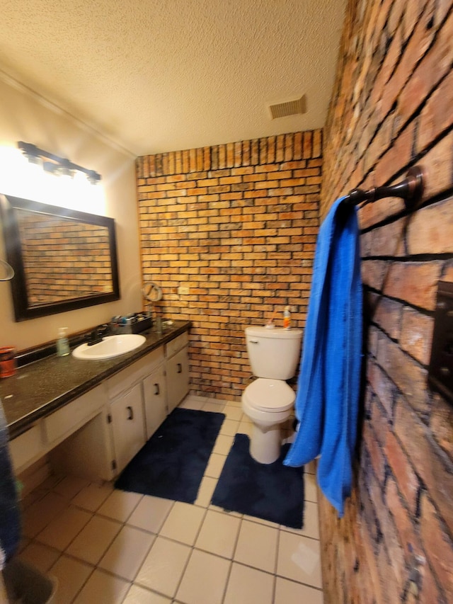 bathroom with a textured ceiling, tile patterned floors, and brick wall