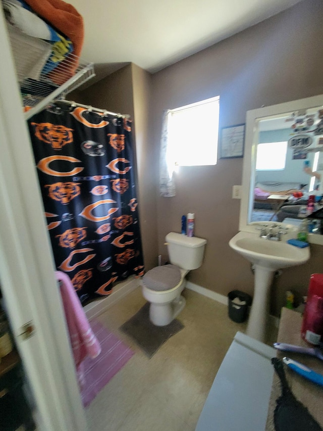 bathroom featuring curtained shower, plenty of natural light, and toilet