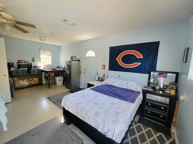 bedroom featuring ceiling fan and stainless steel refrigerator