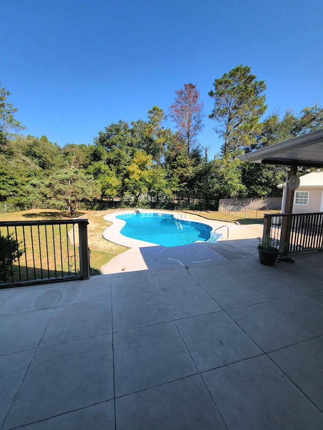 view of swimming pool featuring a patio area and a yard