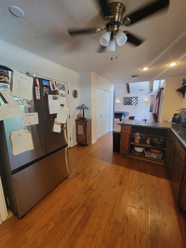 kitchen with hardwood / wood-style floors, stainless steel fridge, a textured ceiling, and ceiling fan