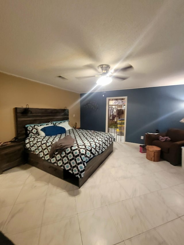 bedroom with a textured ceiling and ceiling fan