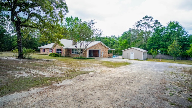 1097 Bob Mccaskill Dr, Defuniak Springs, FL 32433 - single story home with driveway, an attached garage, an outbuilding, and view of scattered trees