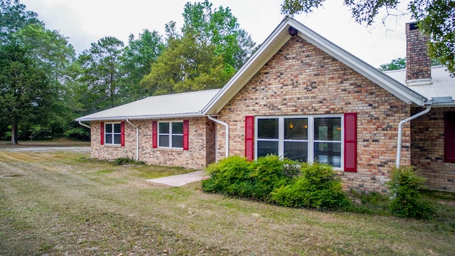 1097 Bob Mccaskill Dr, Defuniak Springs, FL 32433 - ranch-style home featuring a chimney, a front yard, brick siding, and metal roof