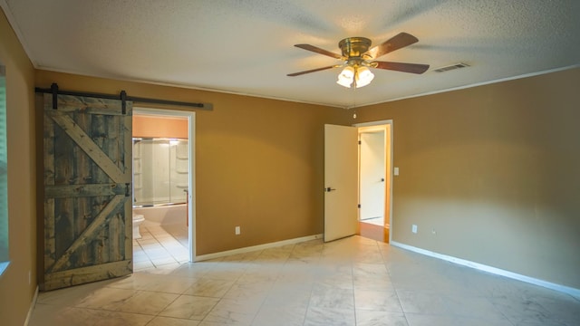 1097 Bob Mccaskill Dr, Defuniak Springs, FL 32433 - unfurnished room featuring a barn door, ceiling fan, a textured ceiling, and baseboards