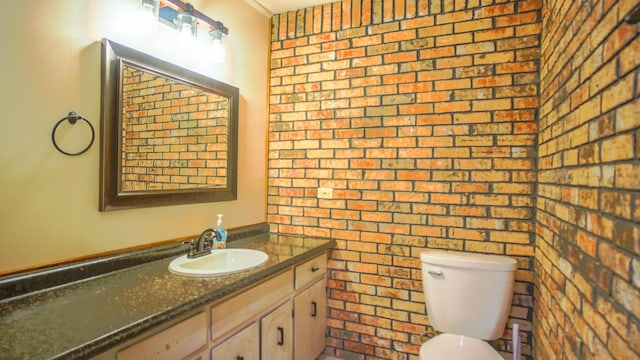 1097 Bob Mccaskill Dr, Defuniak Springs, FL 32433 - half bath featuring brick wall, toilet, ornamental molding, and vanity