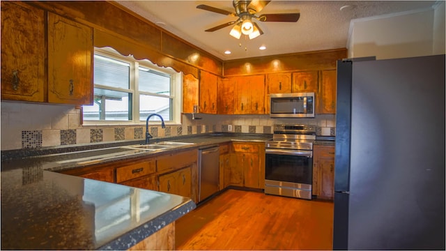 1097 Bob Mccaskill Dr, Defuniak Springs, FL 32433 - kitchen featuring stainless steel appliances, a sink, dark countertops, brown cabinets, and recessed lighting