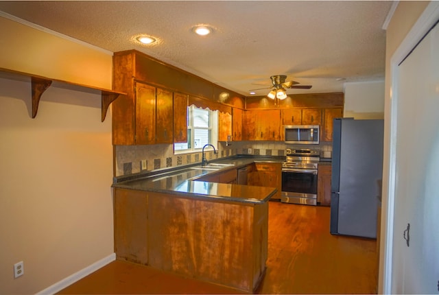 1097 Bob Mccaskill Dr, Defuniak Springs, FL 32433 - kitchen featuring appliances with stainless steel finishes, a peninsula, a sink, open shelves, and brown cabinetry