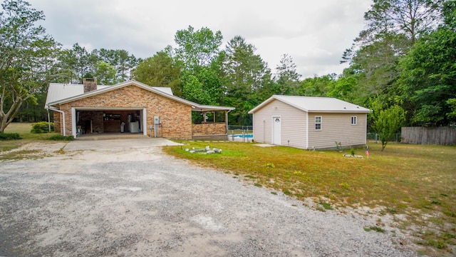 1097 Bob Mccaskill Dr, Defuniak Springs, FL 32433 - view of side of property with a chimney, an outdoor structure, driveway, and view of wooded area