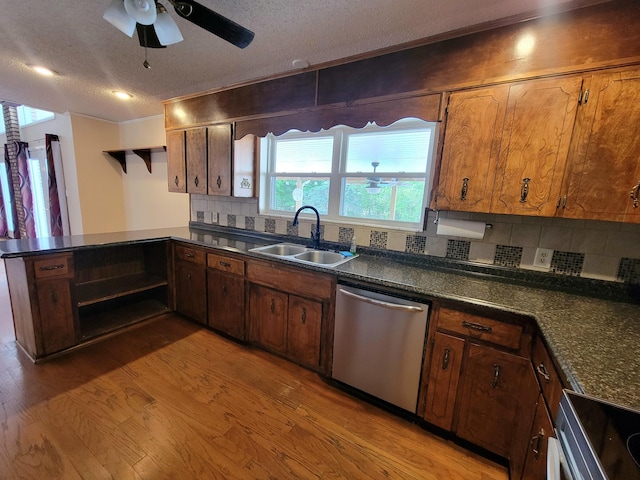 1097 Bob Mccaskill Dr, Defuniak Springs, FL 32433 - kitchen with stainless steel dishwasher, a sink, light wood-style floors, dark countertops, and stove