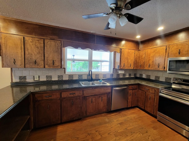 1097 Bob Mccaskill Dr, Defuniak Springs, FL 32433 - kitchen with stainless steel appliances, a sink, a textured ceiling, dark countertops, and brown cabinets