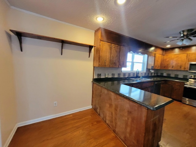 1097 Bob Mccaskill Dr, Defuniak Springs, FL 32433 - kitchen with stainless steel appliances, a sink, open shelves, dark countertops, and a peninsula