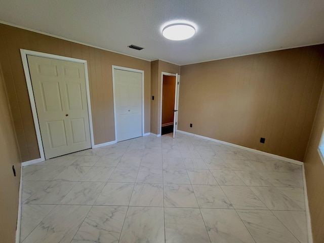 1097 Bob Mccaskill Dr, Defuniak Springs, FL 32433 - unfurnished bedroom featuring light marble finish floors, wooden walls, baseboards, and ornamental molding