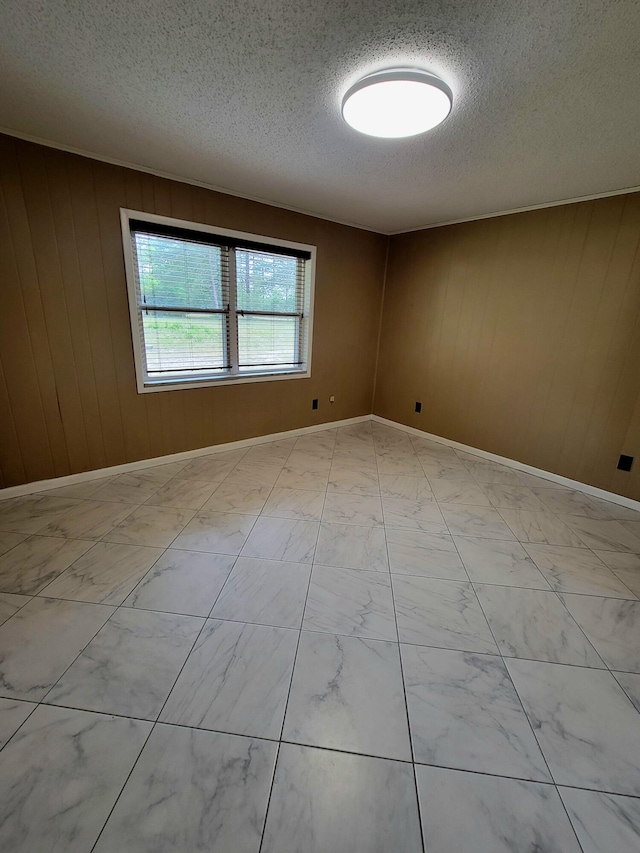 1097 Bob Mccaskill Dr, Defuniak Springs, FL 32433 - unfurnished room featuring a textured ceiling, light marble finish floors, wooden walls, and baseboards