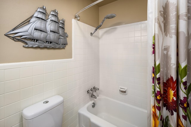 bathroom with tile walls, toilet, and shower / bath combination with curtain