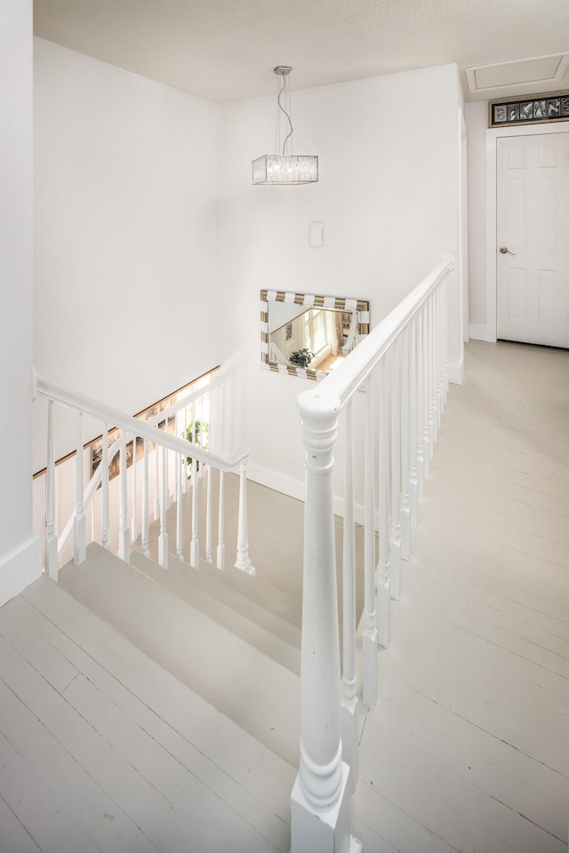 stairs featuring a chandelier