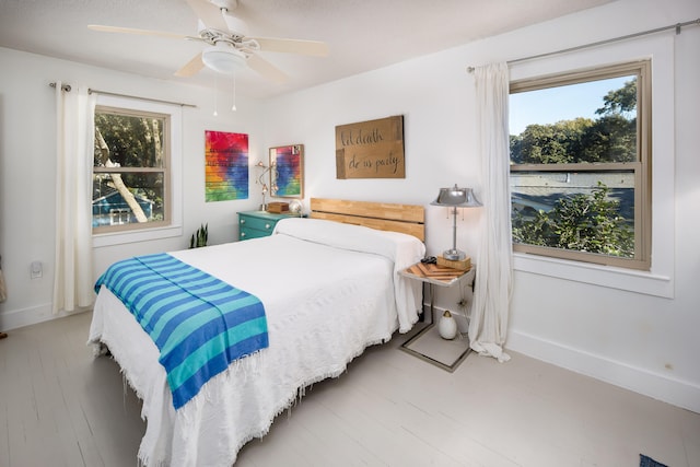 bedroom featuring light hardwood / wood-style flooring, multiple windows, and ceiling fan